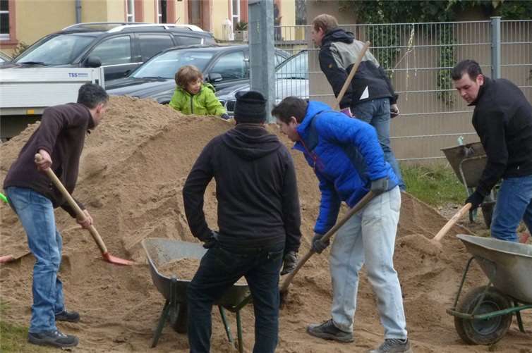 Große und Kleine Helfer verluden den Sand in die Sandkästen.privat