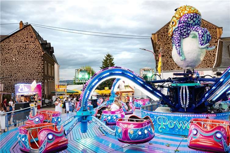Großer Festplatz der Kirmes mit Fahrgeschäften, Buden und Ständen.