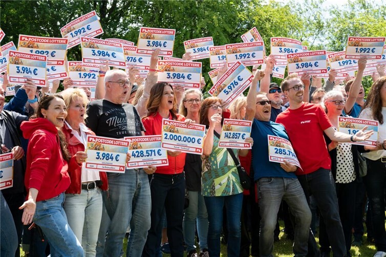 Großer Jubel beim Gewinnerfest: Gemeinsam mit Botschafterin Katarina Witt sowie den Glücksbot*innen Julia Krüger und Felix Uhlig feiern Hunderte Glückspilze den Juni-Monatsgewinn der Postcode Lotterie in Höhe von insgesamt zwei Millionen Euro.