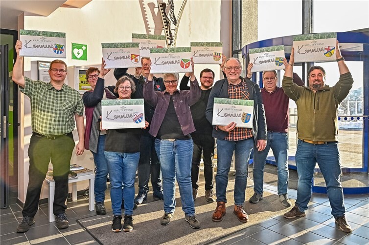Großer Jubel in der Verbandsgemeindeverwaltung: Die Ortsbürgermeister haben die Schilder entgegengenommen, die die erfolgreiche Teilnahme am Projekt „Kräuterwind-Kommune“ signalisieren. Foto:Kräuterwind