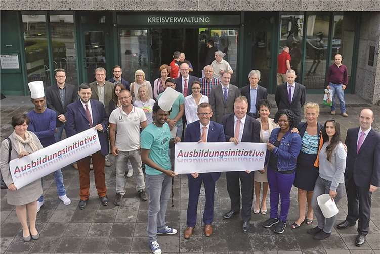 Großer Kreis: Ein Kurs-Teilnehmer aus Eritrea (vorne von links), DEHOGA-Präsident Gereon Haumann und Landrat Dr. Jürgen Pföhler mit Flüchtlingen und EU-Bürgern, die für eine Ausbildung in der Gastronomie fit gemacht werden sollen, sowie weiteren Akteuren der Integrations-Initiative. Hans-Jürgen Vollrath