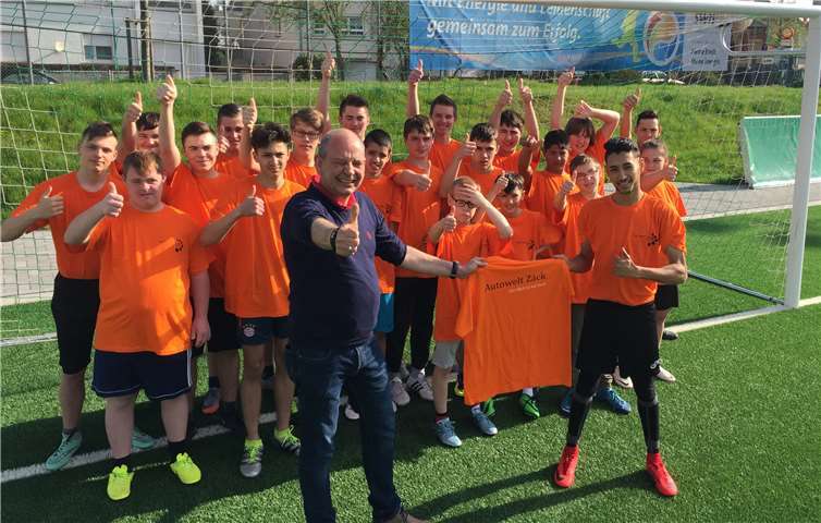 Grund zum Strahlen haben die Fußballer der Carl-Orff-Schule: Nachdem sie sich für das Landesfinale von „Jugend trainiert für Paralympics“ qualifiziert hatten, konnten sie sich jetzt über einen Satz neuer Shirts aus den Händen von Günter Zäck freuen.  privat