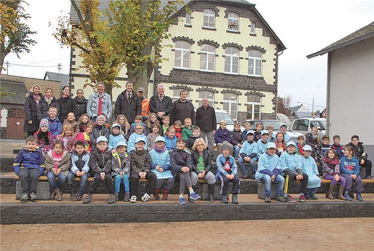 Grundschüler aus Kehrig freuen sich mit ihren Lehrerinnen, Ortsbürgermeister Herbert Keifenheim, RWE-Pate Markus Hickmann, RWE-Kommunalbetreuer Michael Dötsch und den Gemeindebediensteten Michael Barth, Michael Michels und Peter Martini über ein grünes Klassenzimmer im Außengelände. privat