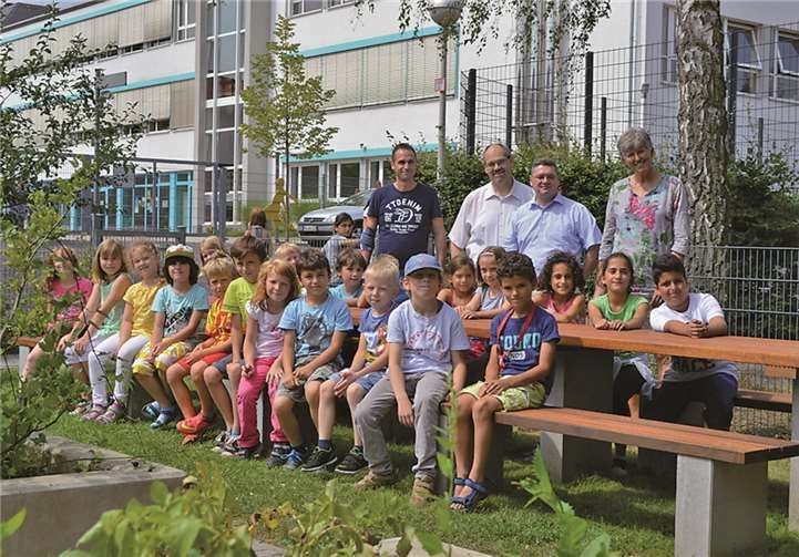 Grundschulkinder mit (v.l.): Markus Mohr, Klaus Kraus, Jens-Uwe Starke und Anjo Närdemann an der tollen Tafel im Schulgarten. AB
