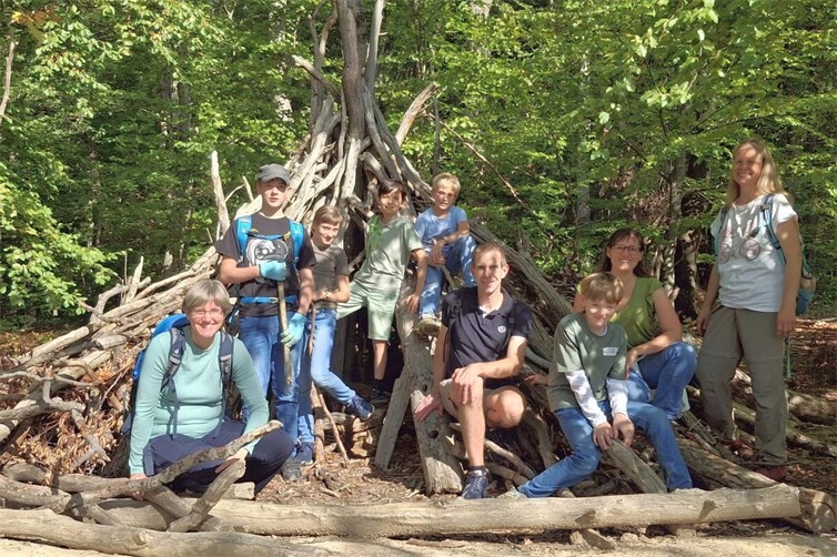 Gruppe an einem der Holzbauten am Wegesrand