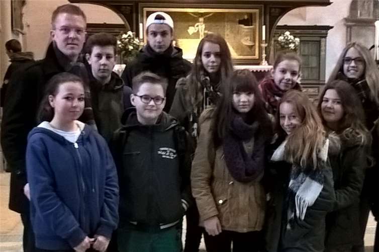 Gruppe der Konfirmandinnen und Konfirmanden mit Betreuer und Pfarrer André Beetschen vor dem Alter der Stadtkirche in Wittenberg. privat