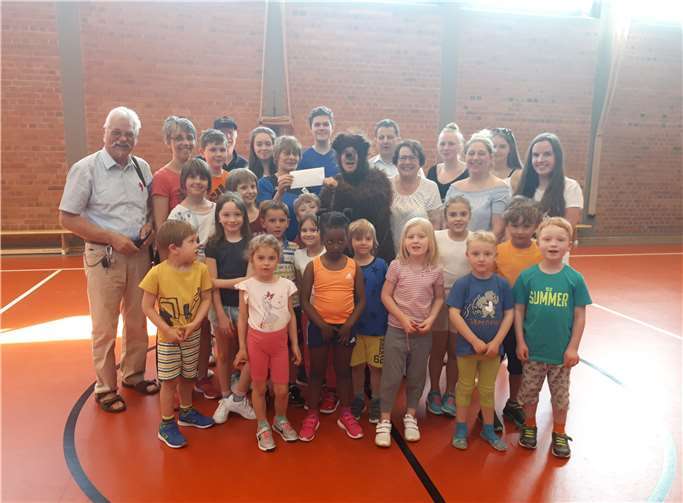 Gruppenbild mit Eazebär (Petra Neft): die Organisatoren der Spendenaktion (Peter Zachow, Ferdinand Theisen, Oliver Neft) mit den Übungsleiterinnen sowie Kindern und Jugendlichen der Abteilung Breitensport des FC Pech.privat