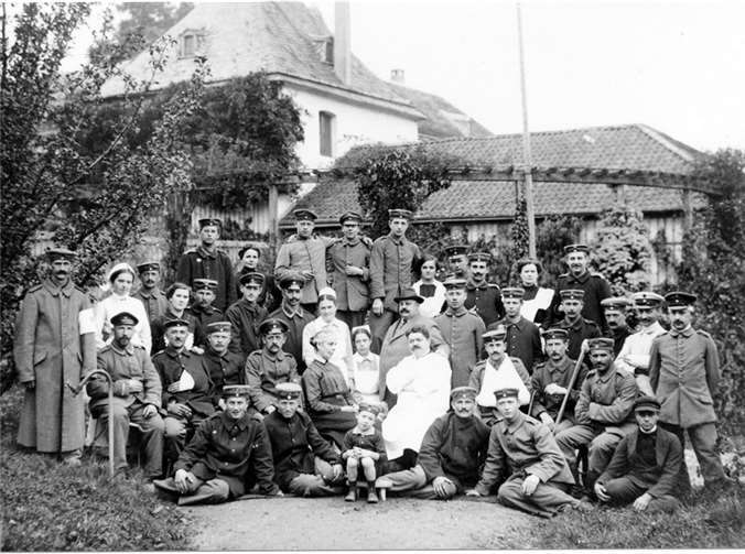 Gruppenbild vor dem Paradiesgarten des Hauses. In der Mitte die Familienmitglieder Marie Rhodius, Marie-Louise Andreae und Hanna Rhodius in Schwesterntracht, Andreas Andreae und Dr. Leyendecker. Repro HG