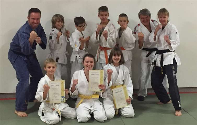 Gruppenfoto mit den Trainern und drei erfolgreichen Prüflingen.