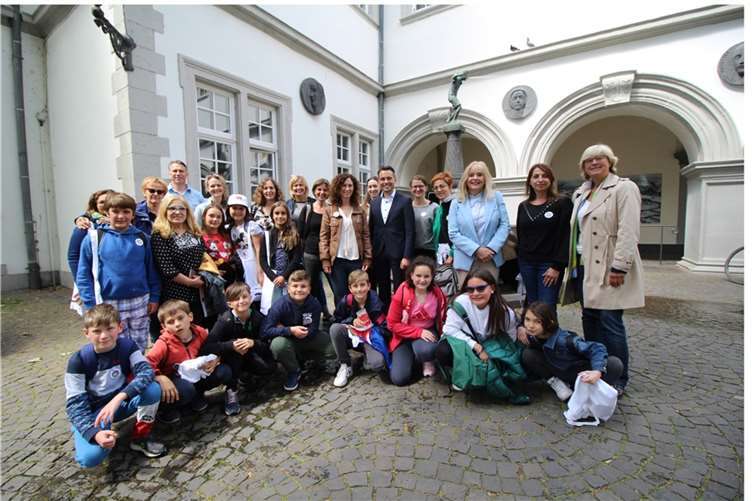 Gruppenfoto vor dem Schängelbrunnen: OB David Langner (stehend, 6.v.r.) und Schuldezernentin Dr. Margit Theis-Scholz (stehend, 3.v.r.) empfingen Schülerinnen und Schüler, sowie deren Lehrerinnen aus dem portugiesischen Madeira und aus Italien. Weiterhin: die Schulleiterin gastgebenden Oberdorfgrundschule, Brita Weingart (stehend 8.v.r), die Beauftragte der ADD für das EU-Erasmusprogramm, Bettina Münch-Rosenthal (stehend, 1.v.r) und der Leiter des städtischen Kultur- und Schulverwaltungsamtes, Jürgen Karbach (stehend, 5.v.l.). Quelle: Stadt Koblenz