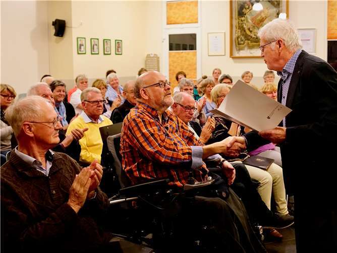 Günter Nerger (vorne rechts), Vorsitzender des Kreis-Chorverbands, übergab die Urkunde des Landeschorverbands an Hans Creuzberg. Foto: KG