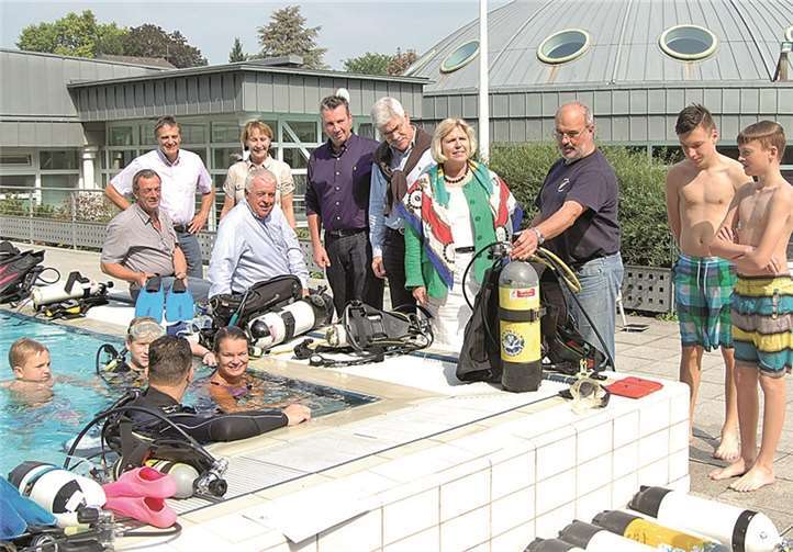 Guido Ernst und Gabriele Hermann-Lersch bei den Sporttauchern des „Schnuppertauchens“ beim Familientag in den Römer-Thermen. Dieter Hessler (3.von rechts) erklärt der Stadtbürgermeisterin gerade die Ausrüstung. FA