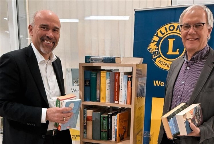 Guido Mombauer und Joachim Willemsen im HIT-Markt beim umsatzkräftigsten Bücherregal des Lions Club.