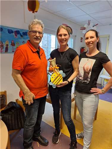 H.-P. Dahm (Klima-Werkstatt) und zwei Erzieherinnen der Kita Maria Himmelfahrt präsentieren ein selbstgebautes Insektenhotel. Foto: Corinna Becker