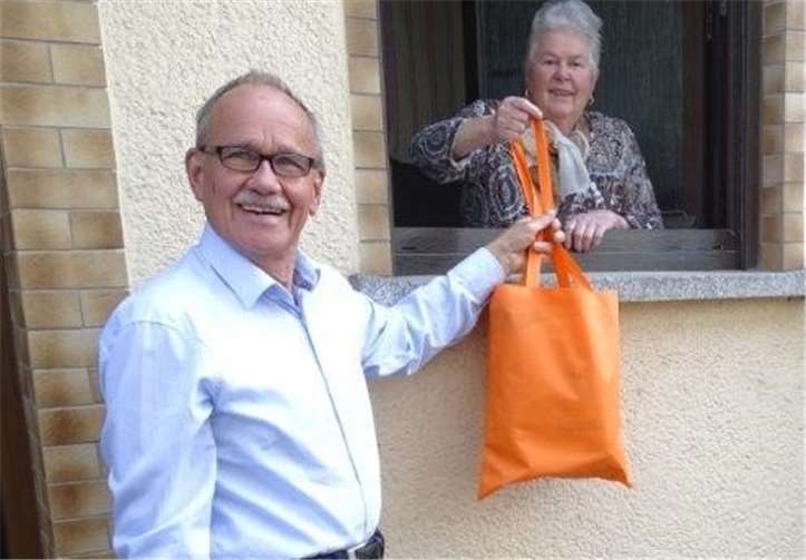 Hajo Reif übergibt eine gut gefüllte Stofftasche an eine Bewohnerin. Foto: privat