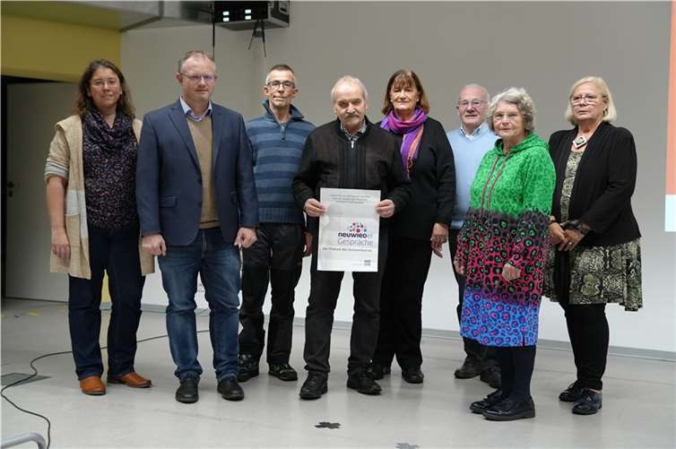 Hans-Georg Poredda (4. von links) und Brigitte Neumann (5. von links) arbeiten gemeinsam mit Andreas Fischer (3. von links) vom OK4 am Podcast. Sandra Mette (1. von links), Oberbürgermeister Jan Einig (2. von links) und der Vorstand des Seniorenbeirats unterstützen das Projekt.  Foto: Stadt Neuwied / Melanie Lange