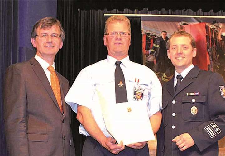 Hans-Günter Fischer und Thomas Nelles überreichten Hans-Günter Gombert das Silbernen Feuerwehr-Ehrenzeichen am Bande. DL