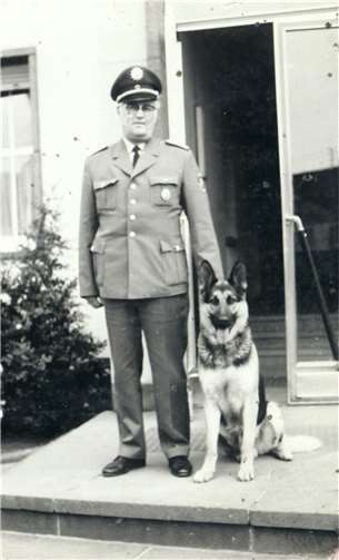 Hans Hoffmann mit Diensthund Bodo vor dem Rathaus.  Foto: Archiv F. G. Bell