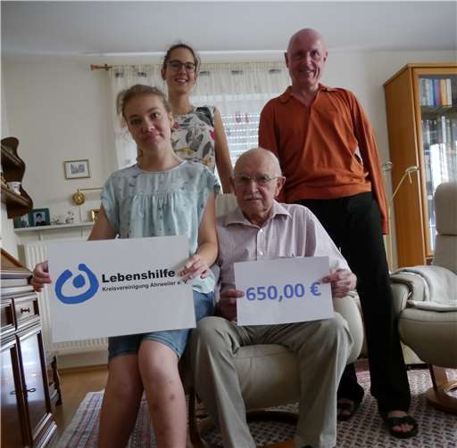 Hans Klinger und seine Enkelin Lara Creuzberg überreichen das gesammelte Geld an Ulrich van Bebber, Vorstandsvorsitzenden der Lebenshilfe Kreisvereinigung Ahrweiler e.V. und Verena Rönneper, Assistentin der Geschäftsführung. privat