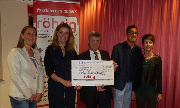 Hans Peter (Mi.) und Volker Röhrig (2. v. re.) mit Partnerin Anna (re.) sowie Yvonne Röhrig (li.) bei der Überreichung eines Schecks in Höhe von 10.000 Euro für Kinderhilfsprojekte an Schirmherrin Heike Boomgaarden. Privat