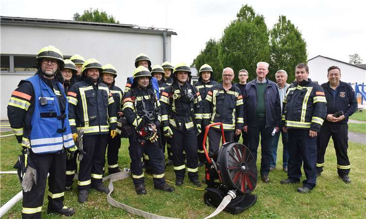 Hans Schäfer (4. v. l.) übergibt den Hochleistungslüfter an die Kripper Feuerwehr um Einheitsführer Ingo Wolf (2. v. l.) bei einer Übung an der Grundschule. Foto: AB