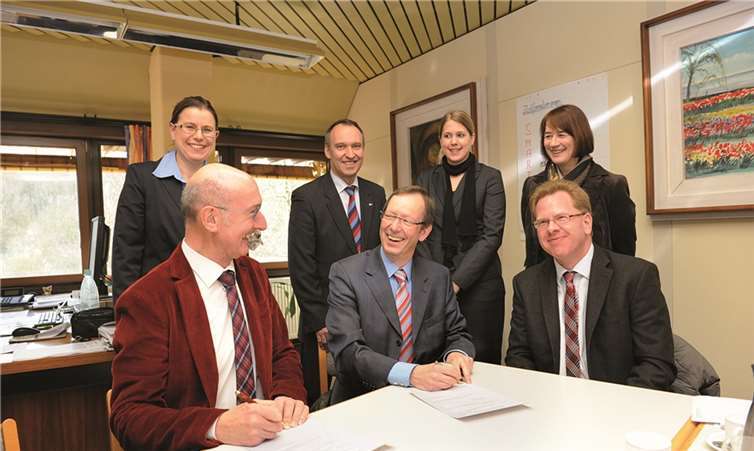 Hans-Werner Rieck und Peter Jansen (sitzend, v. l.) bei der Unterzeichnung des Kooperationsvertrags. FIX