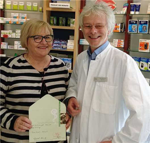 Hauptgewinnerin Annelie Schallert freut sich über den Gutschein von Apotheker Jörg Bergmann. privat