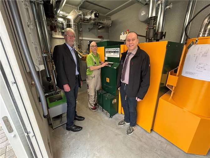 Hausmeister Jörg Quirbach (Mitte) erläutert Bürgermeister Johannes Bell (rechts) und Ortsbürgermeister Rolf Hans (links) die umweltfreundliche Pelletheizung in der Bausenberghalle Niederzissen.  Foto: Peter Engels, VG Brohltal)