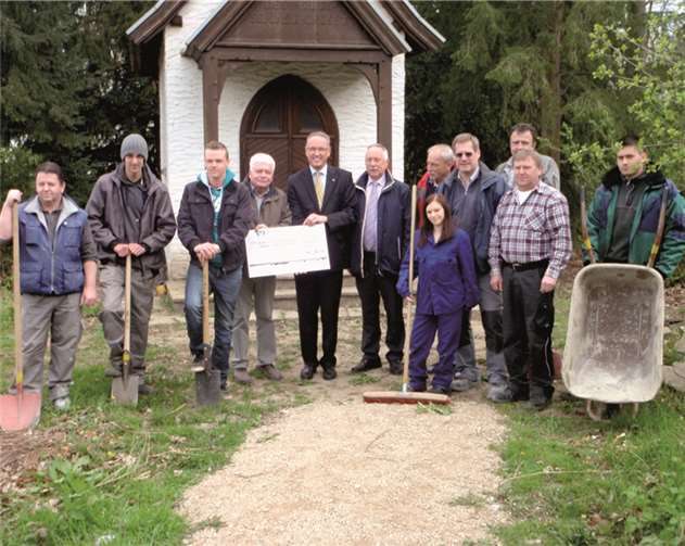 Heinz Haubrichs, Vorstandssprecher und Hans-Josef Assenmacher, Regionalmarktleiter der Raiffeisenbank Rheinbach Voreifel eG überreichen die Spende an das Förderprojekt „Neue Pfade - Georgsing e.V.“  Privat