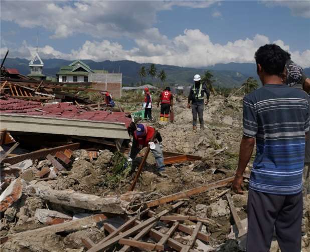 Helfer bei Aufräumarbeiten in der zerstörte Stadt Palu.