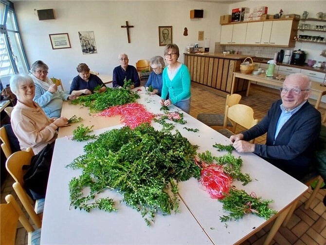 Helfer binden Palmsträuße in Neuwied.  Foto: Christoph Menzenbach