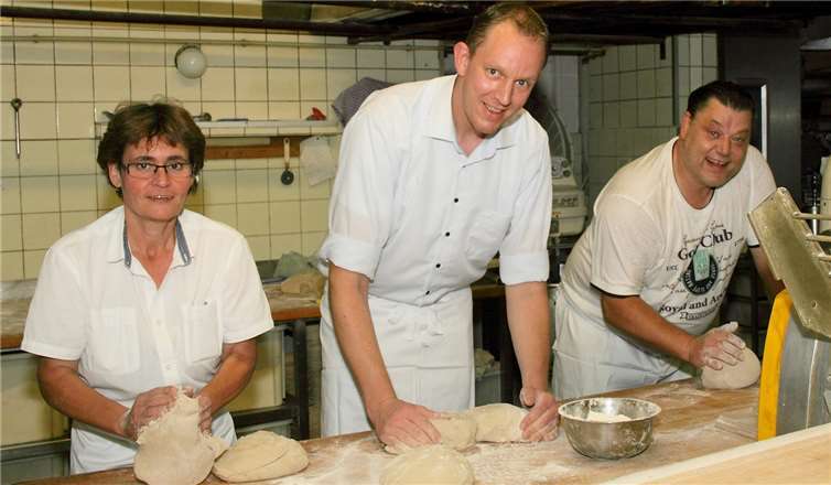 Helga Schmitt-Federkeil und Michael Kappl beweisen unter Anleitung von Frank Schmickler ihr handwerkliches Geschick beim Kneten des Eifeler Brotteigs.  Johann Kappl
