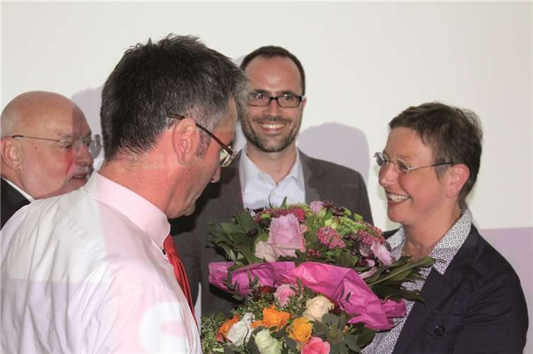 Hendrik Hering gratuliert Karin Küsel-Ferber mit einem Blumenstrauß.