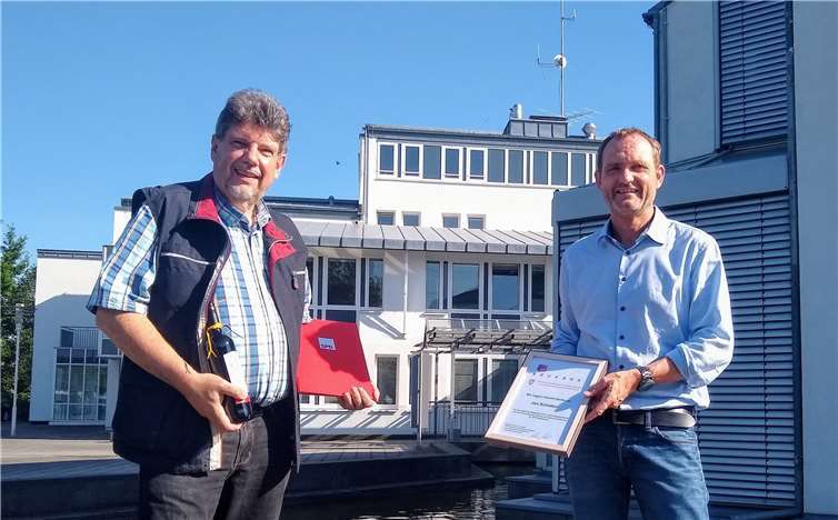 Herbel (l.) überreicht Schatton (r.) die Präsente vor dem Verwaltungsgebäude der VG. Quelle: SPD VG Weißenthurm
