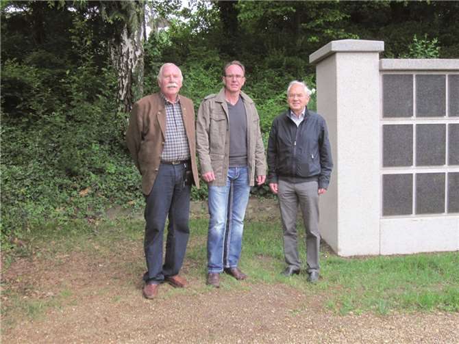 Hermann Leuning (Ortsvorsteher Heimerzheim, Ralf Bramer (Meditec Rheinland) und Robert Datzer (Vize-Bürgermeister und Ratsmitglied) prüfen den Standort für die Bank an den neuen Urnenwänden.privat
