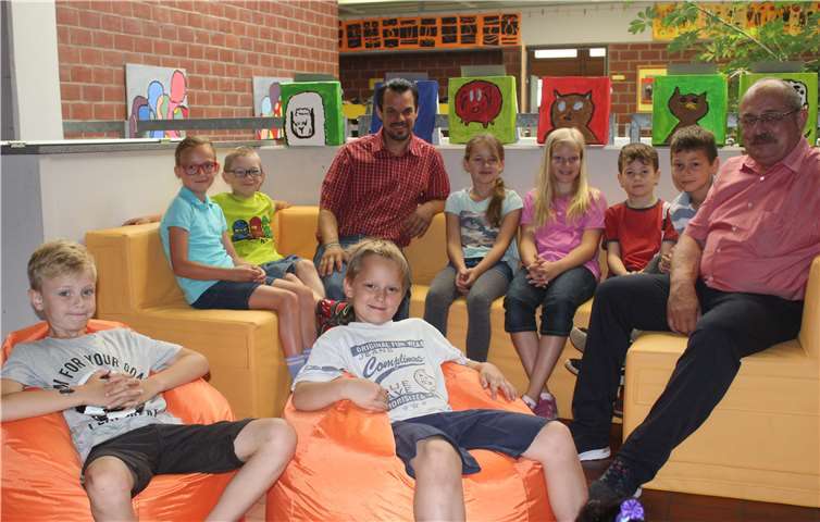 Herr Gerhardt, Herr Kaiser und einige Schüler machen es sich in den neuen Sitzgelegenheiten der Grundschule bequem.privat