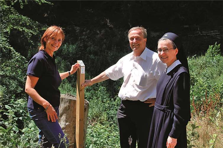 Herr Jung, Frau Heuer und Sr. Elvira mit dem Hinweisschild, welches an der Schulwaldfläche aufgestellt wurde.