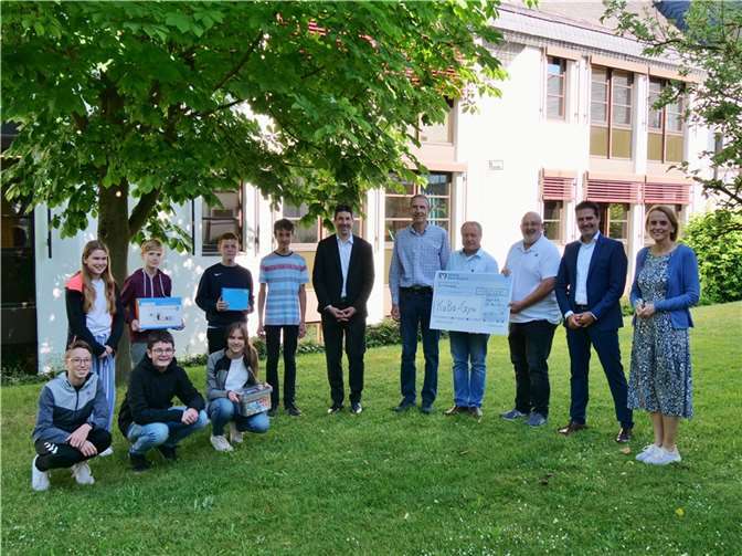 Herr Probstfeld und Herr Wey von der VR Bank, ebenso Schulleiterin Frau Hofmann, Herr Wilbert, Herr Schäfer und Fördervereinsvorsitzender Herr Spitzley sowie Schülerinnen und Schüler bei der Spendenübergabe.  Foto: KuBa
