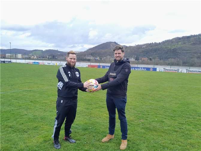 Herr Schilling überreicht zwei Bälle.