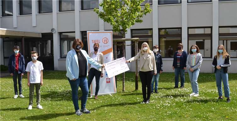Herzlich wurden Christiane Böttcher (Mitte links) und Angelika Schorn (Dritte von rechts) am Gymnasium Calvarienberg empfangen. Schülerinnen und Schüler der Klasse 7 c waren bei der Spendenübergabe durch Direktorin Dr. Annette Gies (Mitte rechts) und Sportlehrerin Christina Weber (Mitte) dabei. Die 350 Euro sind für die spendenfinanzierte Tafel eine große Hilfe. Foto: E.T. Müller