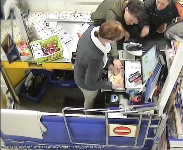 Hier greift der Täter nach dem Geld in der Kasse.