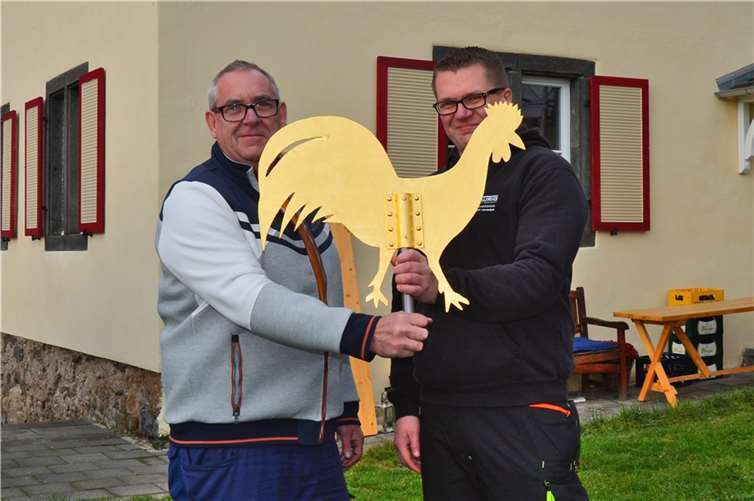 Horst Berens, Vorsitzender von MIT e.V (links), übergibt den goldenen Gockel zur Montage an Dachdeckermeister Michael Beuster-Waurig.Fotos: privat