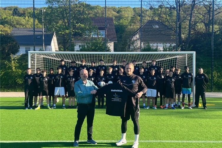 Horst Thuro überreicht die neuen Trainingspullover an die B-Jugend der JSG Bachem/Walporzheim