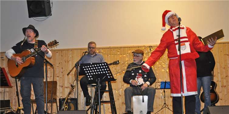 Horst Weber gibt den Weihnachtsmann, unterstützt von Frontmann Wolfgang Nagel (3.v.li.) und seiner Band.Foto: Bürgerstiftung Meckenheim