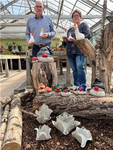 Hühner, Wichtel, Glashalter und vieles mehr: Unter der Regie von Tanja Hübinger-Dahlem (rechts) entstehen in der Gärtnerei der Caritas-Werkstätten in Niederelbert viele tolle Deko-Artikel. Auch Betriebsleiter Lothar Wirth ist von dem kreativen Projekt begeistert. Foto: Caritasverband Westerwald-Rhein-Lahn e.V.