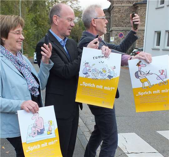 Humorvoll ist die Plakataktion des Kinderschutzbundes – und mit Humor nahm Bürgermeister Thilo Becker (Mitte) mit Heidi Ramb (l.) und Joachim Türk (r.) vom Kinderschutzbund die offizielle Übergabe der ersten Plakate. Aber das Thema ist ernst: Eltern richten allzu oft den Blick auf ihr Smartphone statt aufs eigene Kind. Foto: privat