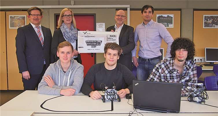 Ilka Kimmel überreicht zusammen mit ihrem Kollegen Christian Neubauer Schulleiter Rainer Probst einen Scheck in Höhe von 1.000 Euro. Physiklehrer Leif-Erik Grabe sowie die Schüler Alexander Kurig, Nils Katzorke und Manuel Wendling freuen sich über die Anschaffung von zwei neuen Robotern. Privat