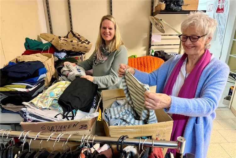 Im Anziehpunkt Montabaur stapeln sich die Kleiderspenden: Einrichtungsleiterin Vera Zimmermann (links) und Mitarbeiterin Beate Seibert sortieren im Lager die eingehenden Spenden – und das, was hier zu sehen ist, ist nur ein Bruchteil der riesigen Mengen. Foto: Caritasverband WWRL/Holger Pöritzsch
