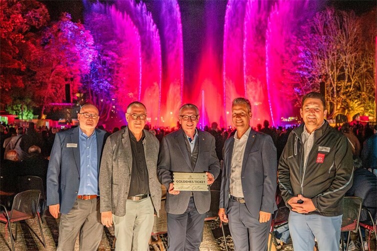 Im Beisein des Ersten Beigeordneten Peter Diewald (2. V. l.) sowie von Bürgermeister Pascal Rowald (2. V. r.) überreichten die Geschäftsführer der AMG, Andreas Lambeck (l.) und Jan Ritter, das Goldene Klangwelle-Ticket an Guido Orthen.