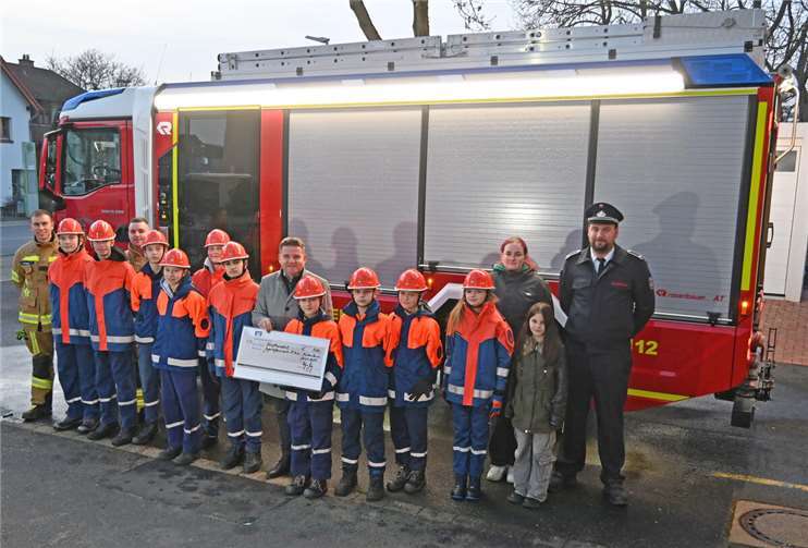 Im Beisein des Stadtjugendwarts Sebastian Kesternich (4.v.l.) und des stellvertretenden Wehrleiters Fabian Althoff (rechts) übergibt Bürgermeister Holger Jung (9.v.l.) den Spendenscheck stellvertretend an die Jugendfeuerwehr der Löschgruppe Lüftelberg. Foto: Stadt Meckenheim